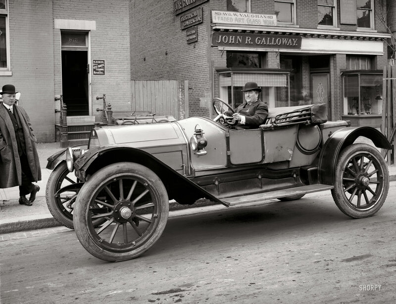 Man in vintage car on street