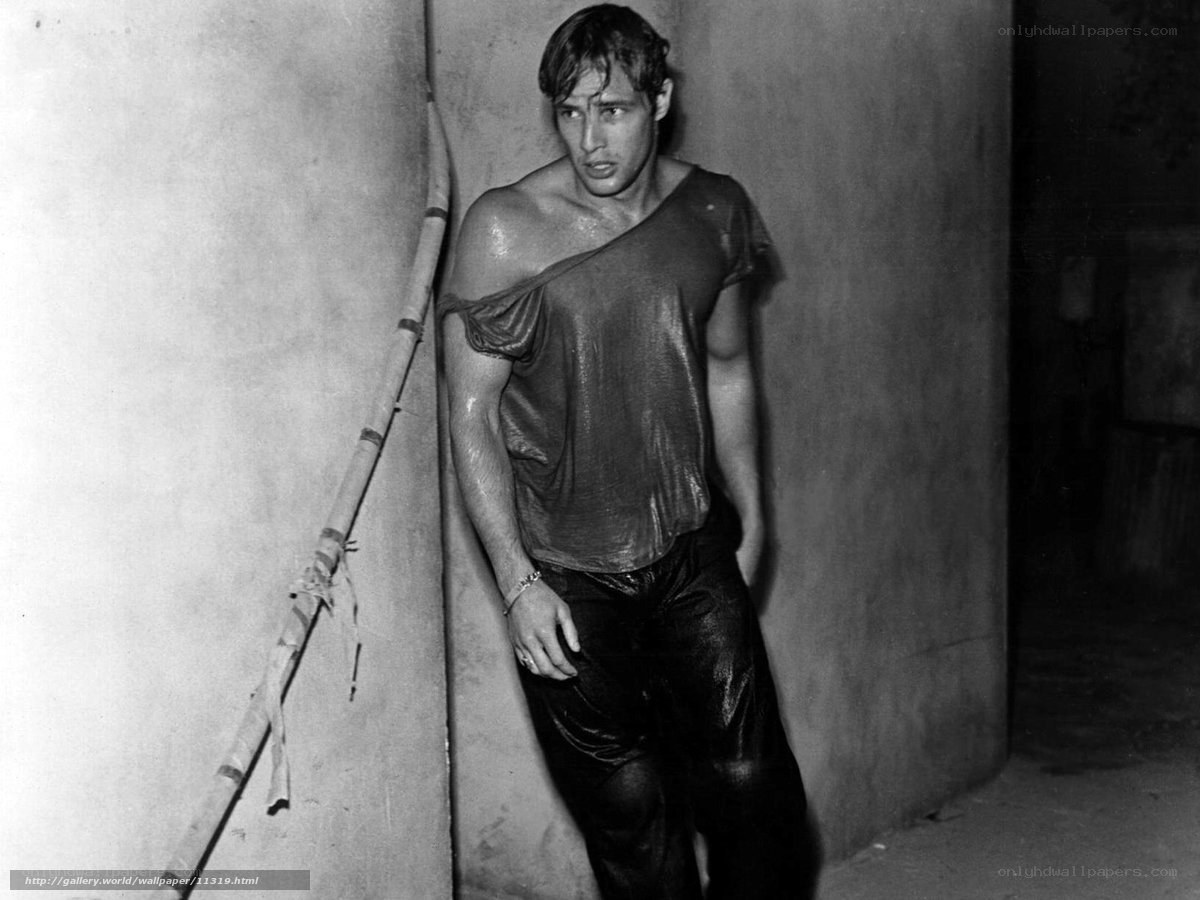 man in wet clothes leaning against wall