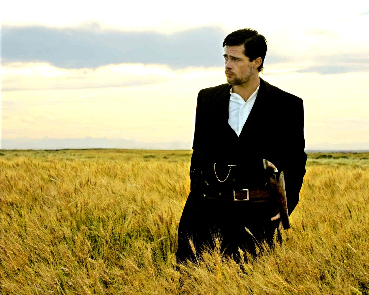man in wheat field with gun