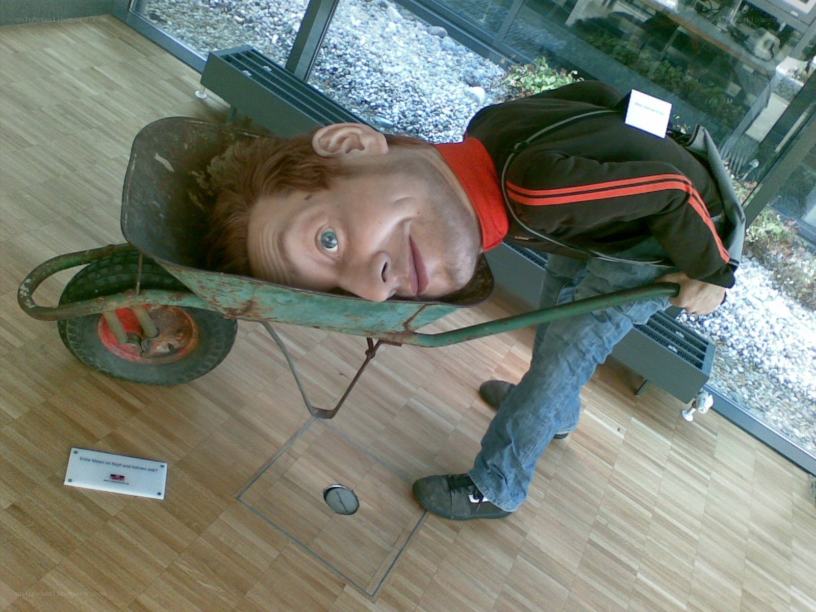 Man in wheelbarrow head sculpture