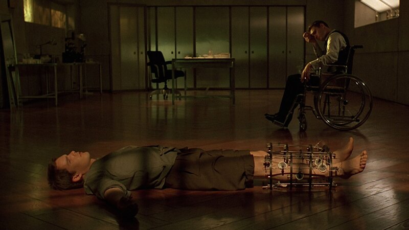 Man in wheelchair observes man on floor