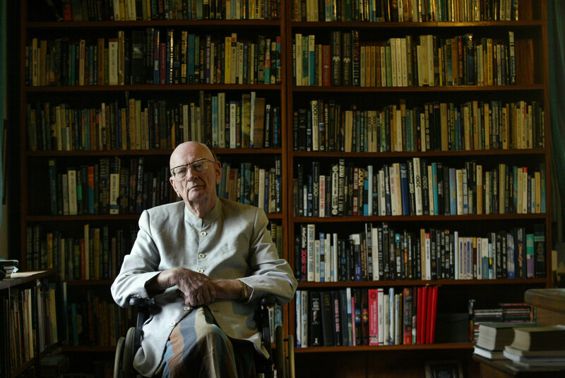 Man in wheelchair with bookshelf