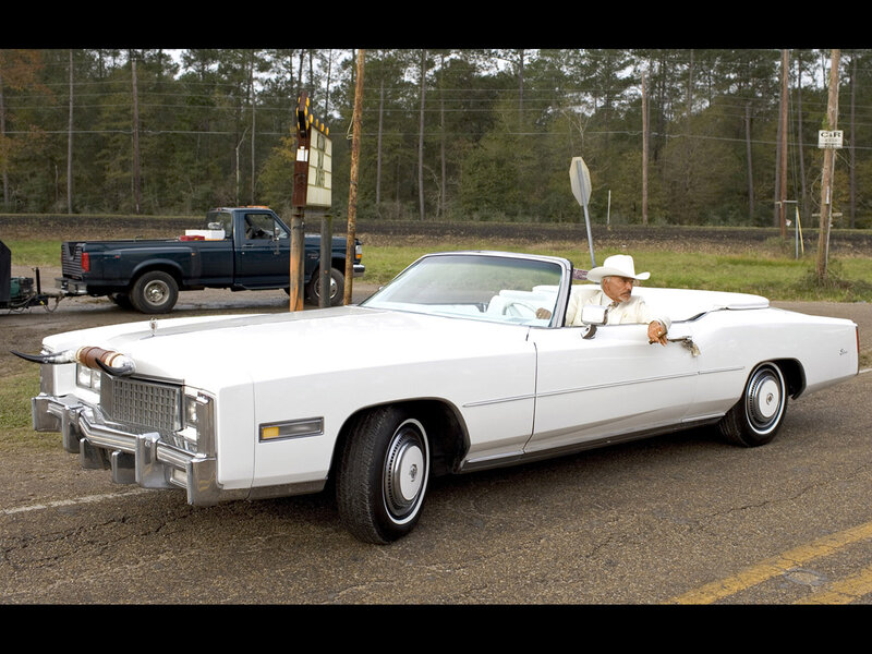 Man in white car with cowboy hat