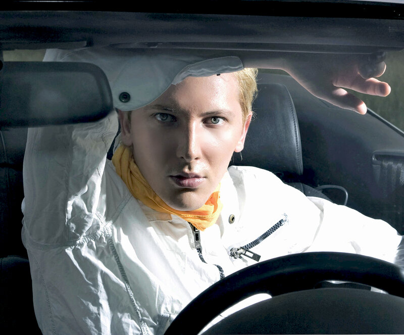 man in white jacket driving car