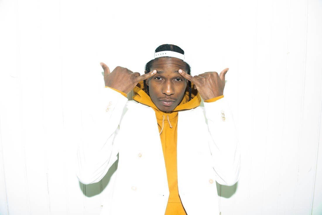 man in white jacket pointing at head