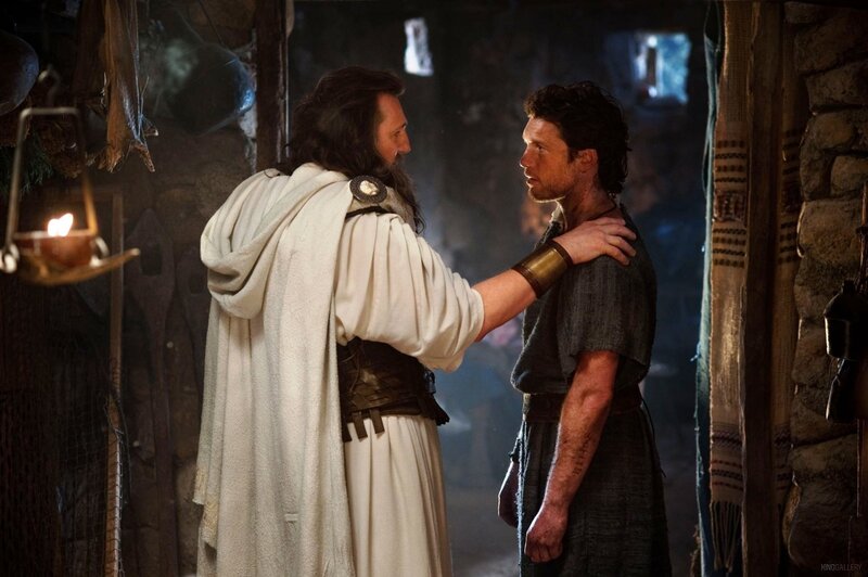 man in white robe with hand on another man's shoulder