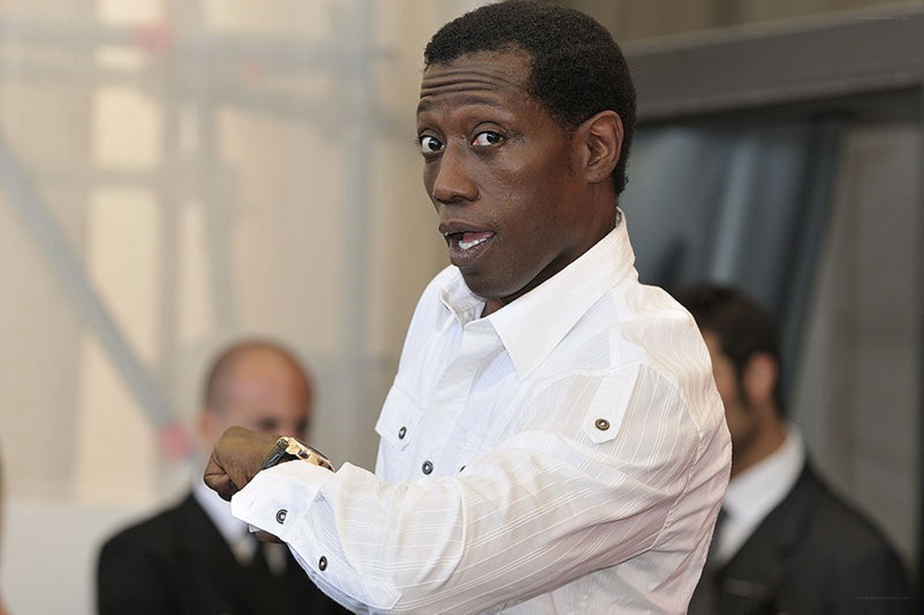 man in white shirt looking at watch