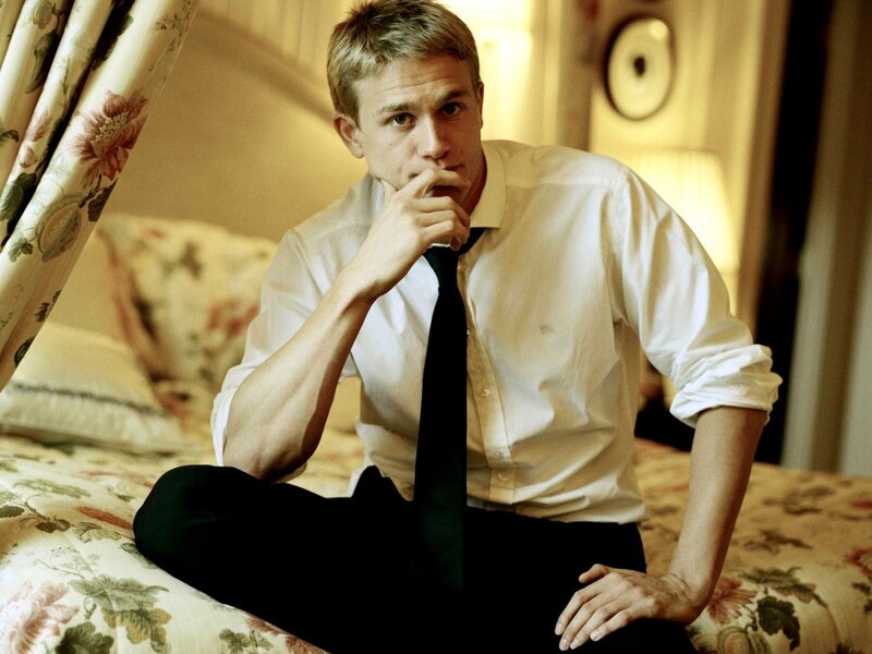 man in white shirt sitting on bed