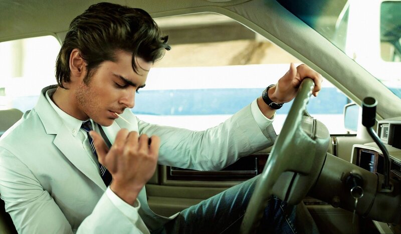 man in white suit driving car