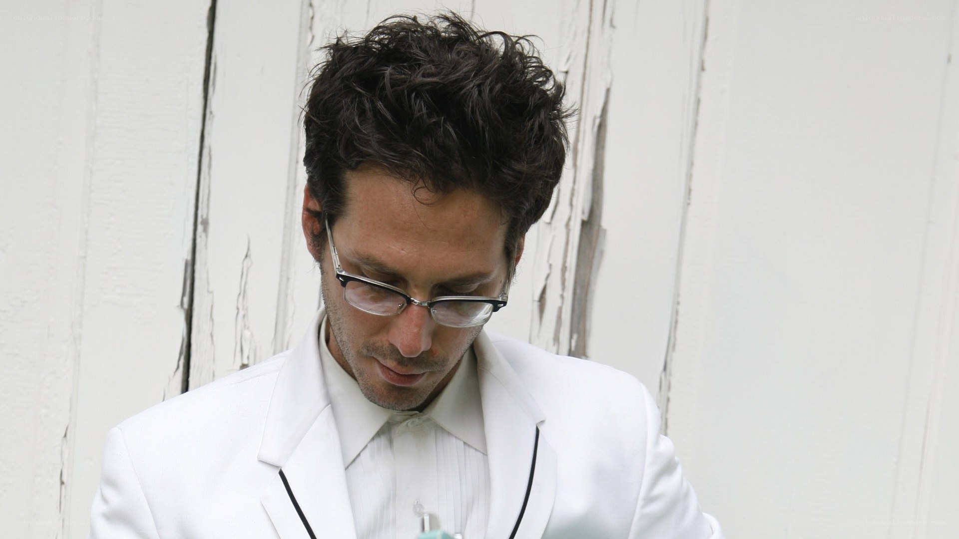 man in white suit looking down