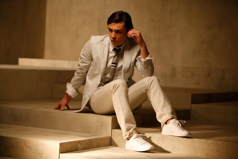 man in white suit sitting on stairs