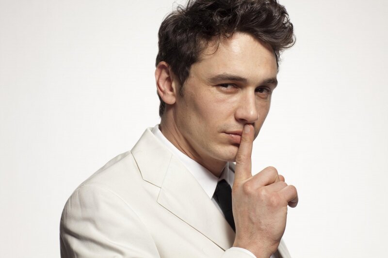 man in white suit with finger to lips