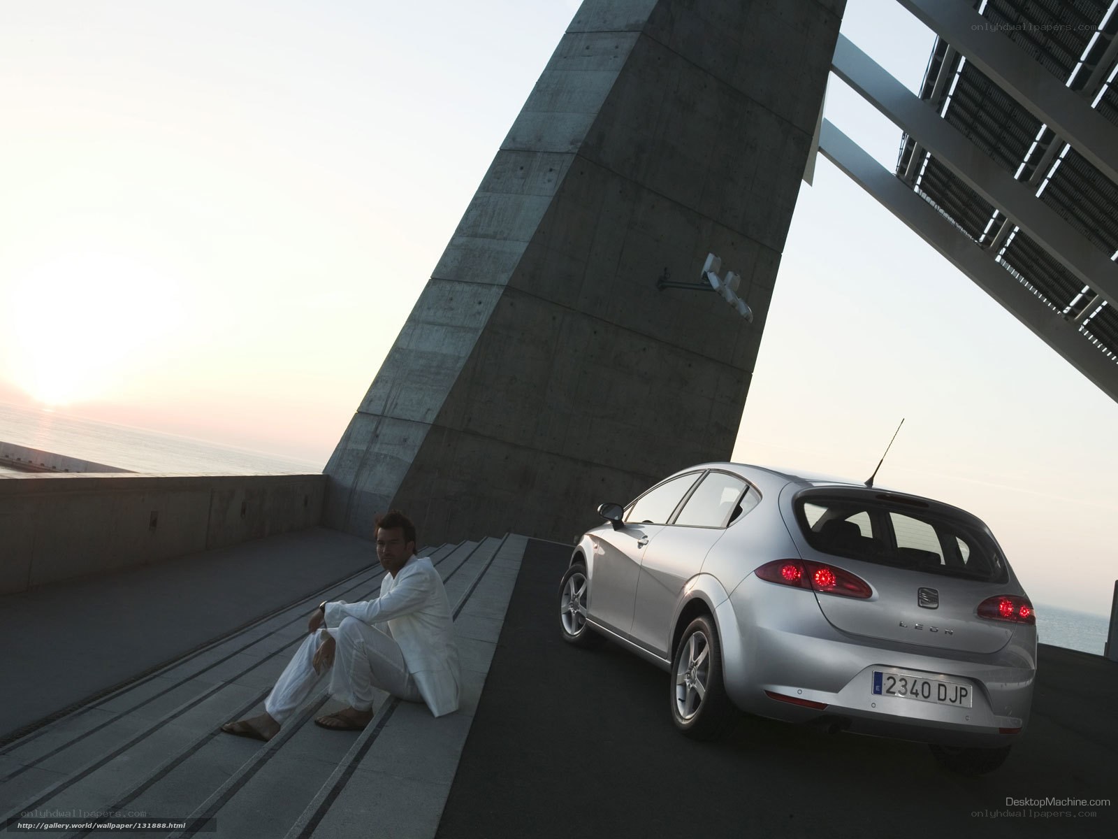 Man in white suit with silver car