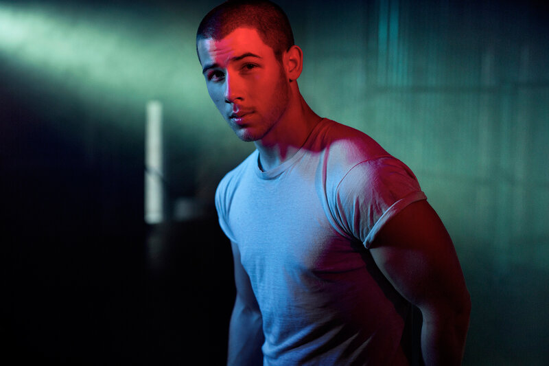 man in white t-shirt under colored lights