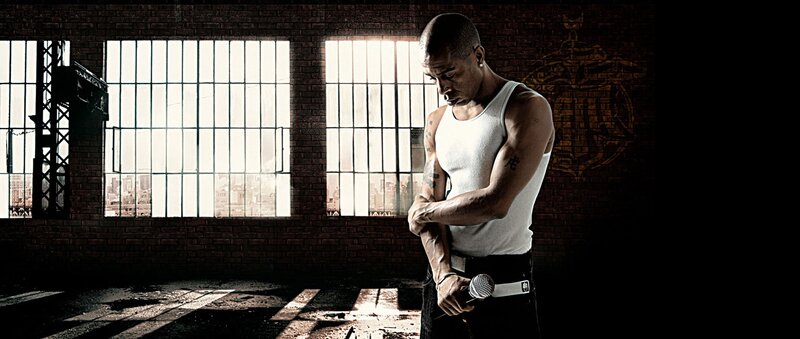 man in white tank top holding microphone