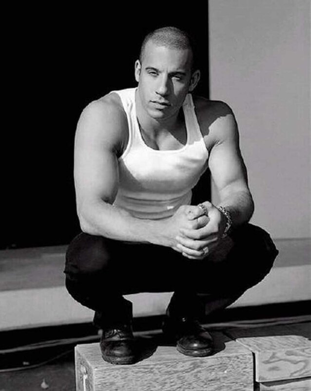 man in white tank top squatting