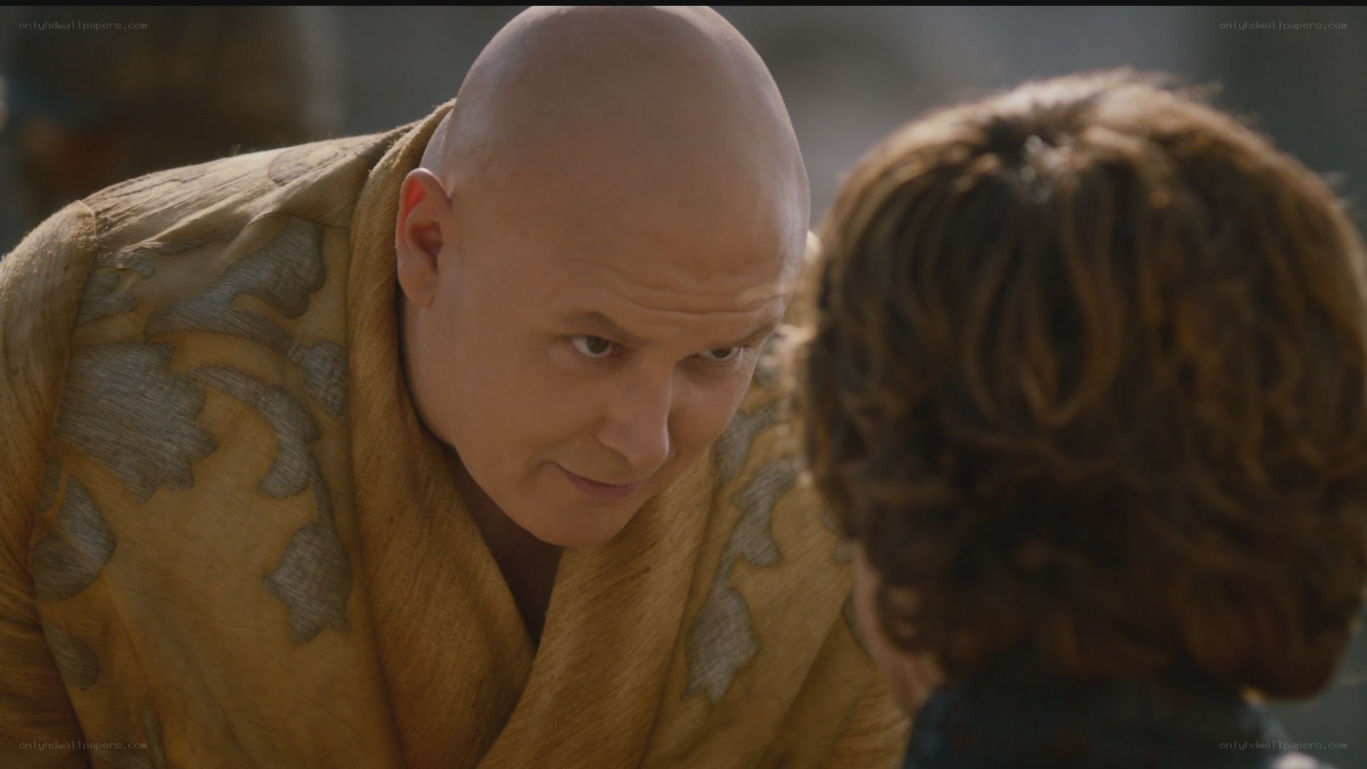 man in yellow robe speaking