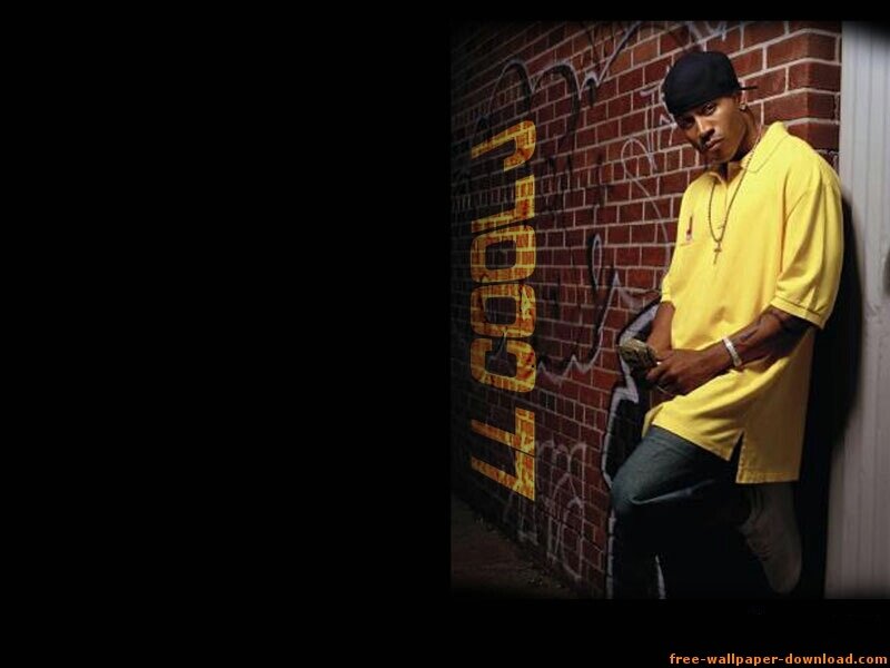 man in yellow shirt against brick wall