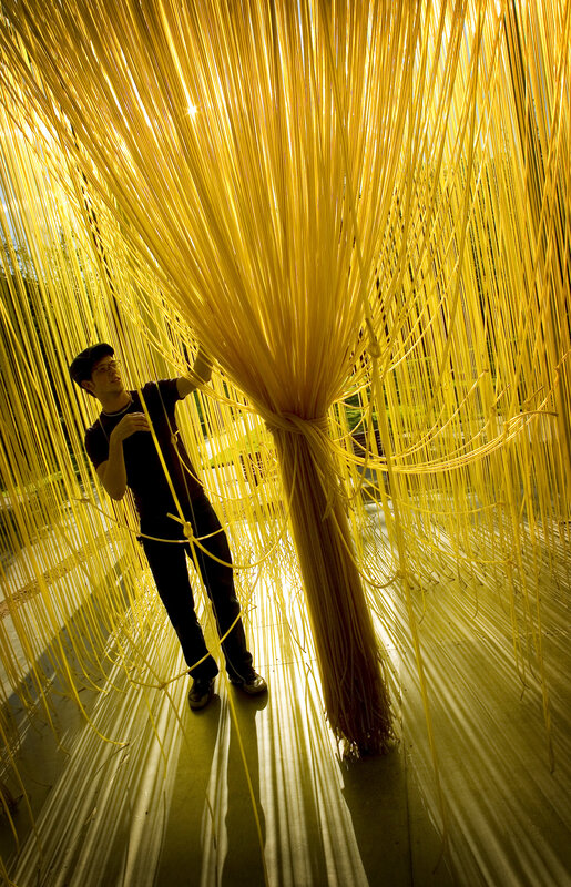 Man in yellow string installation