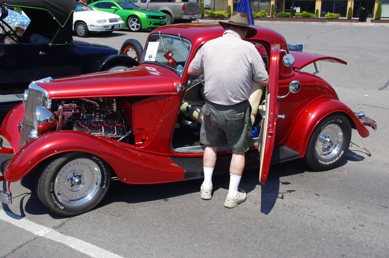 Man Inspecting Red Car