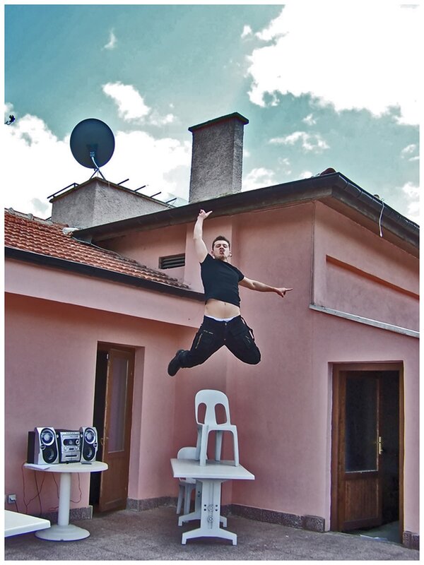 Man jumping in front of house