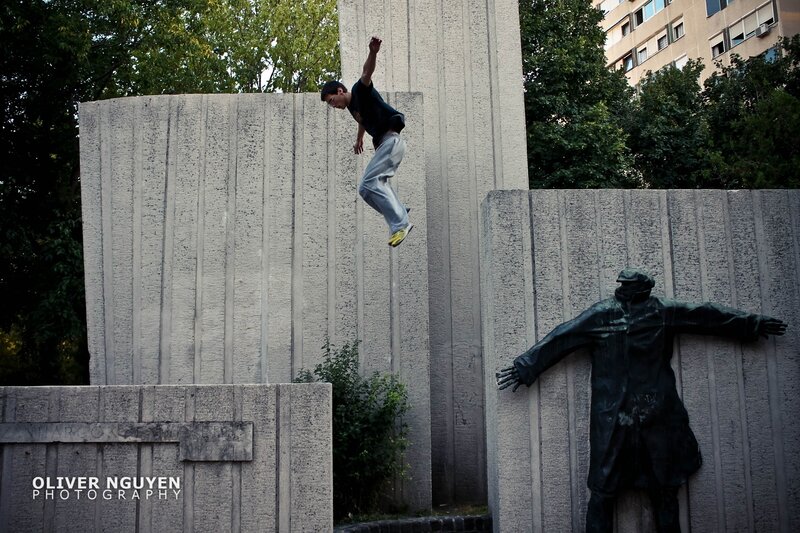 Man jumping over a monument