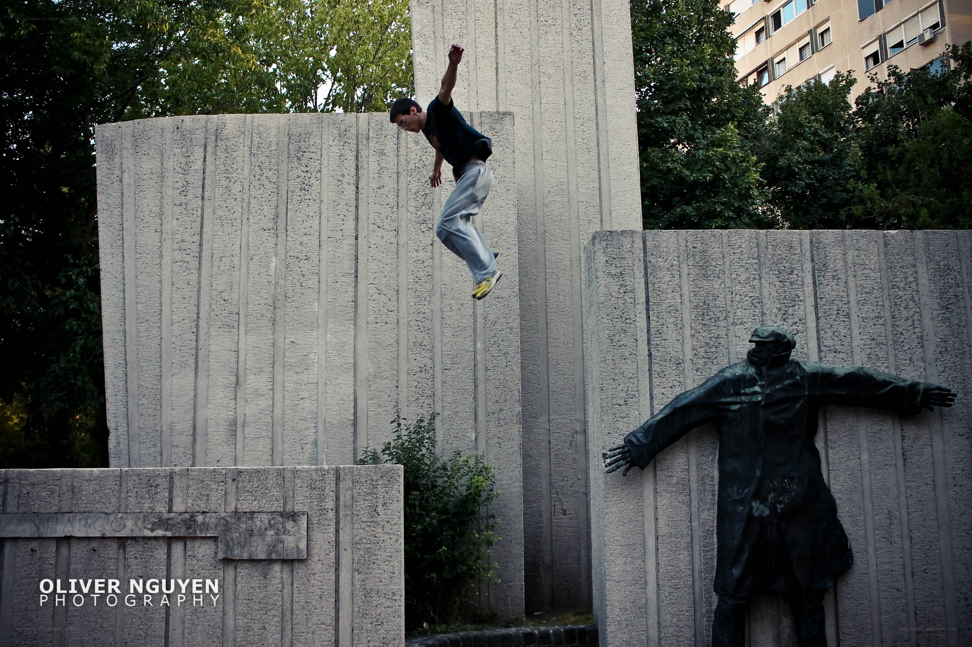 Man jumping over a monument