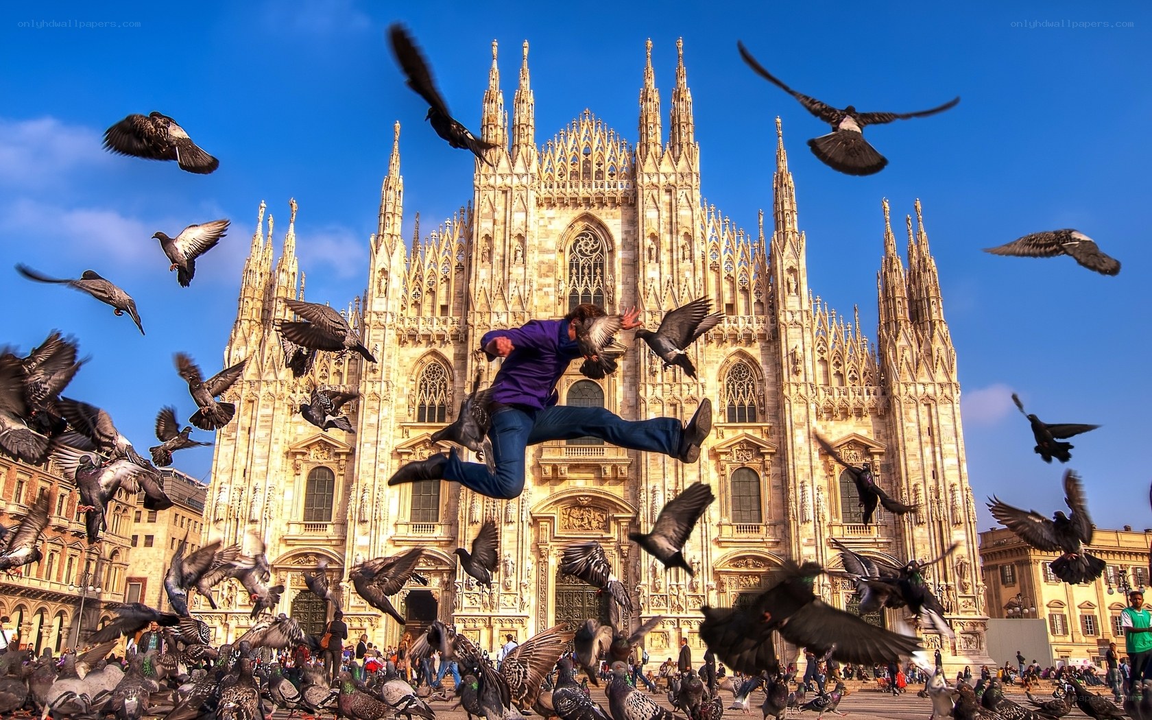 Man jumping with pigeons at Duomo