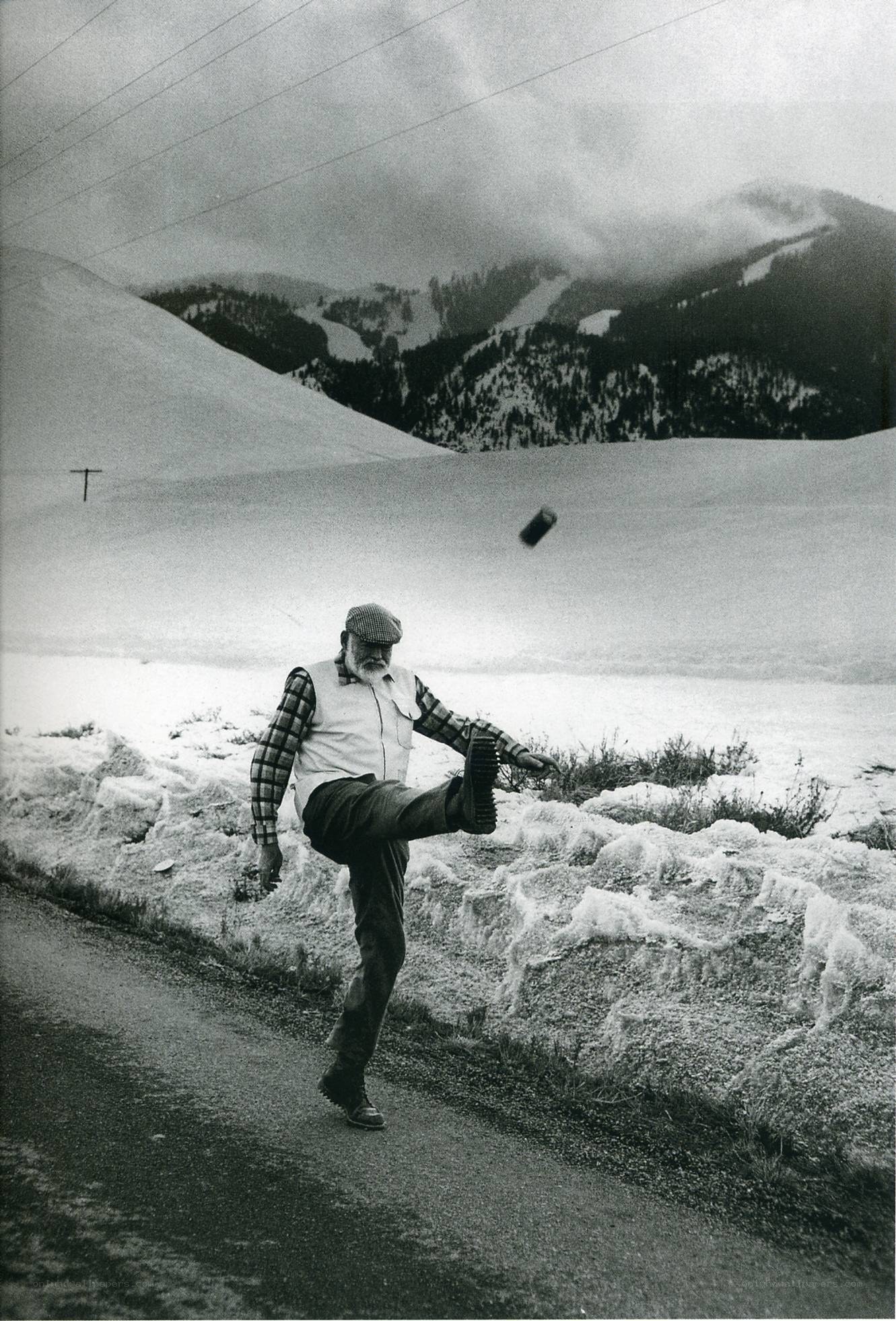 Man kicking can in snowy landscape