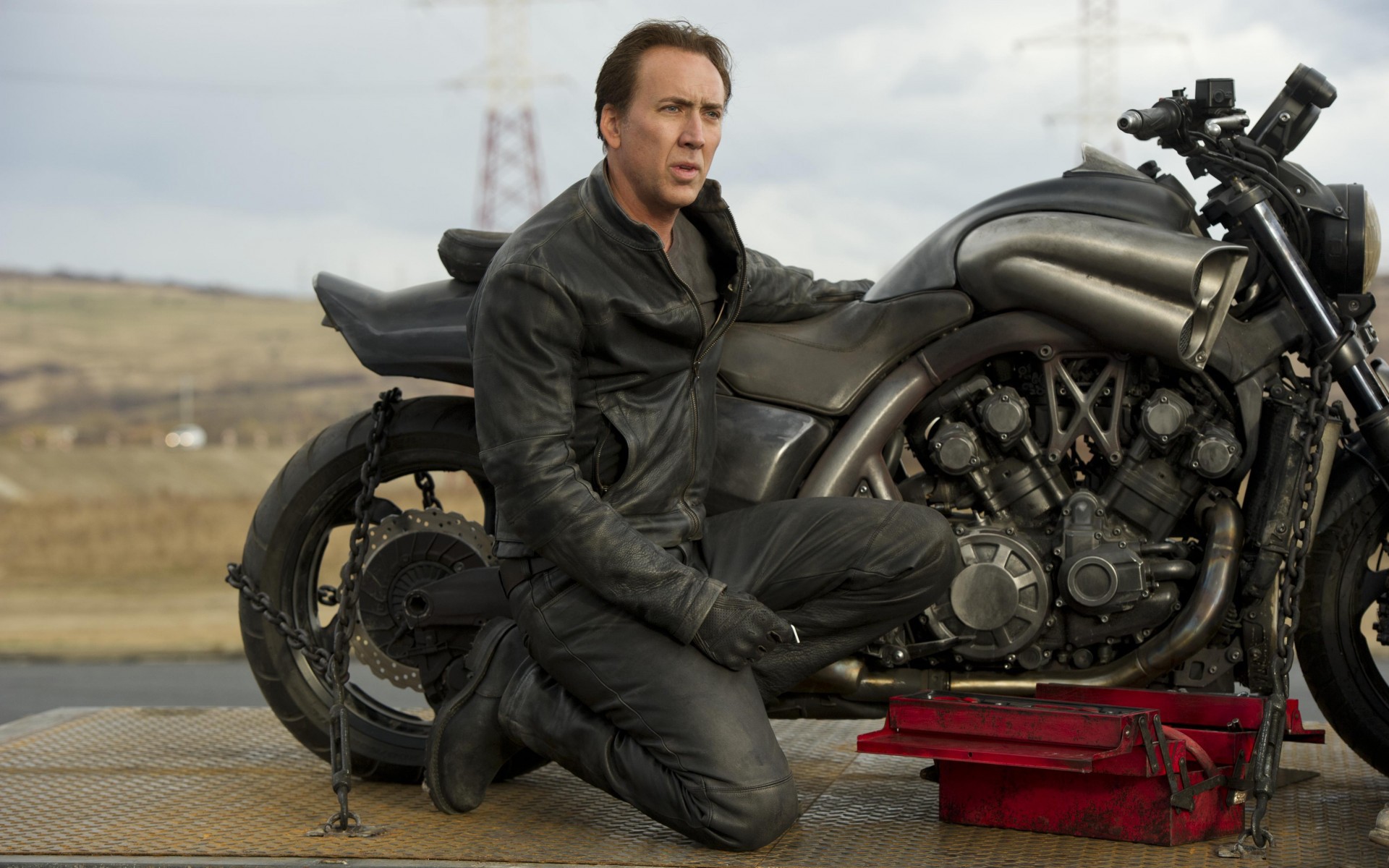 man kneeling beside motorcycle