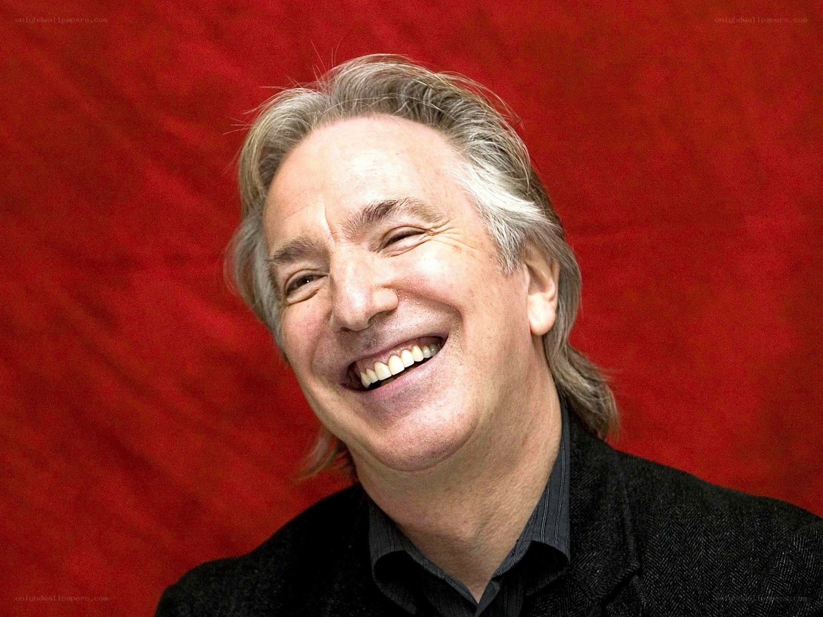 man laughing against red background