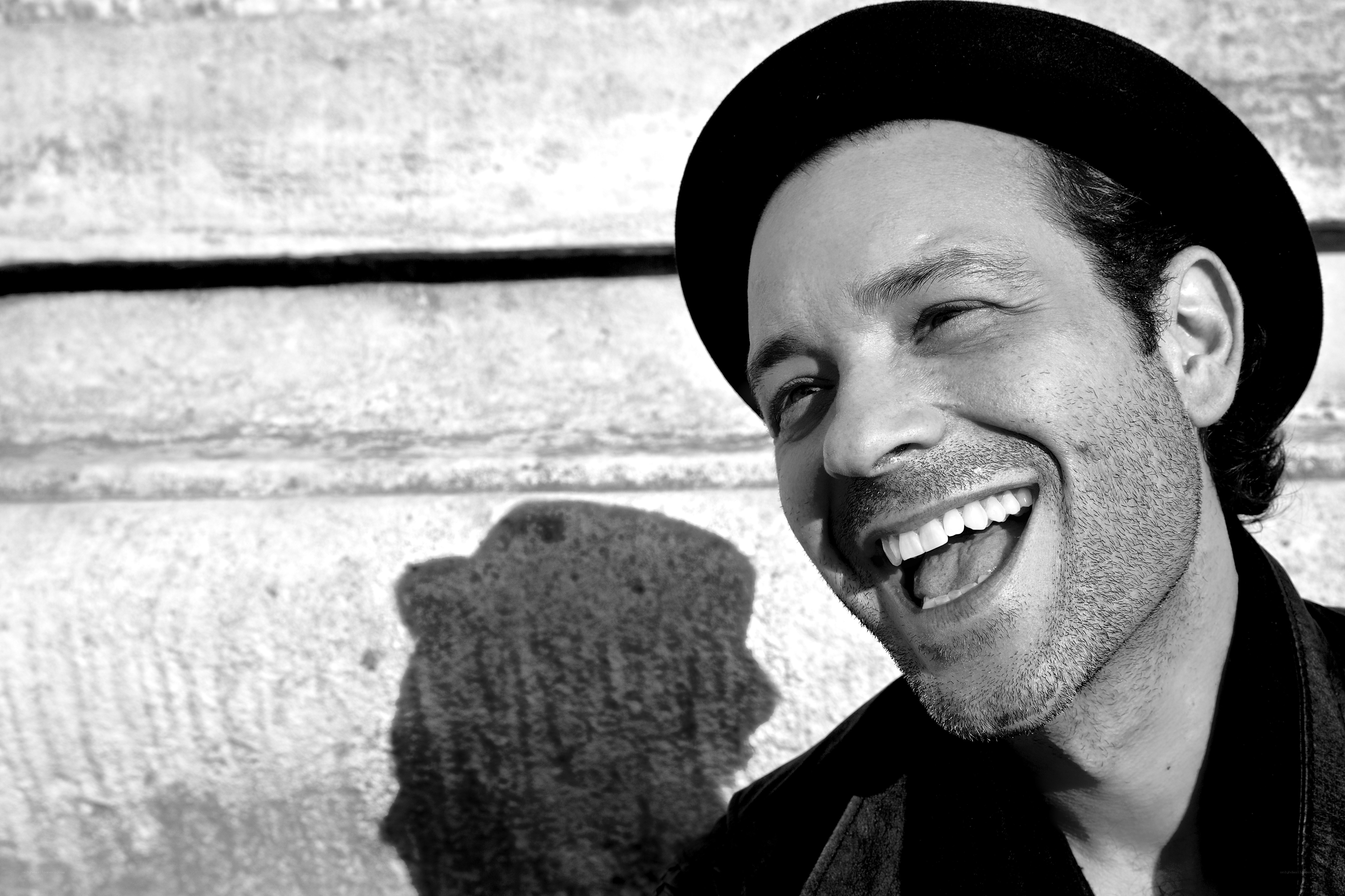 man laughing in black hat