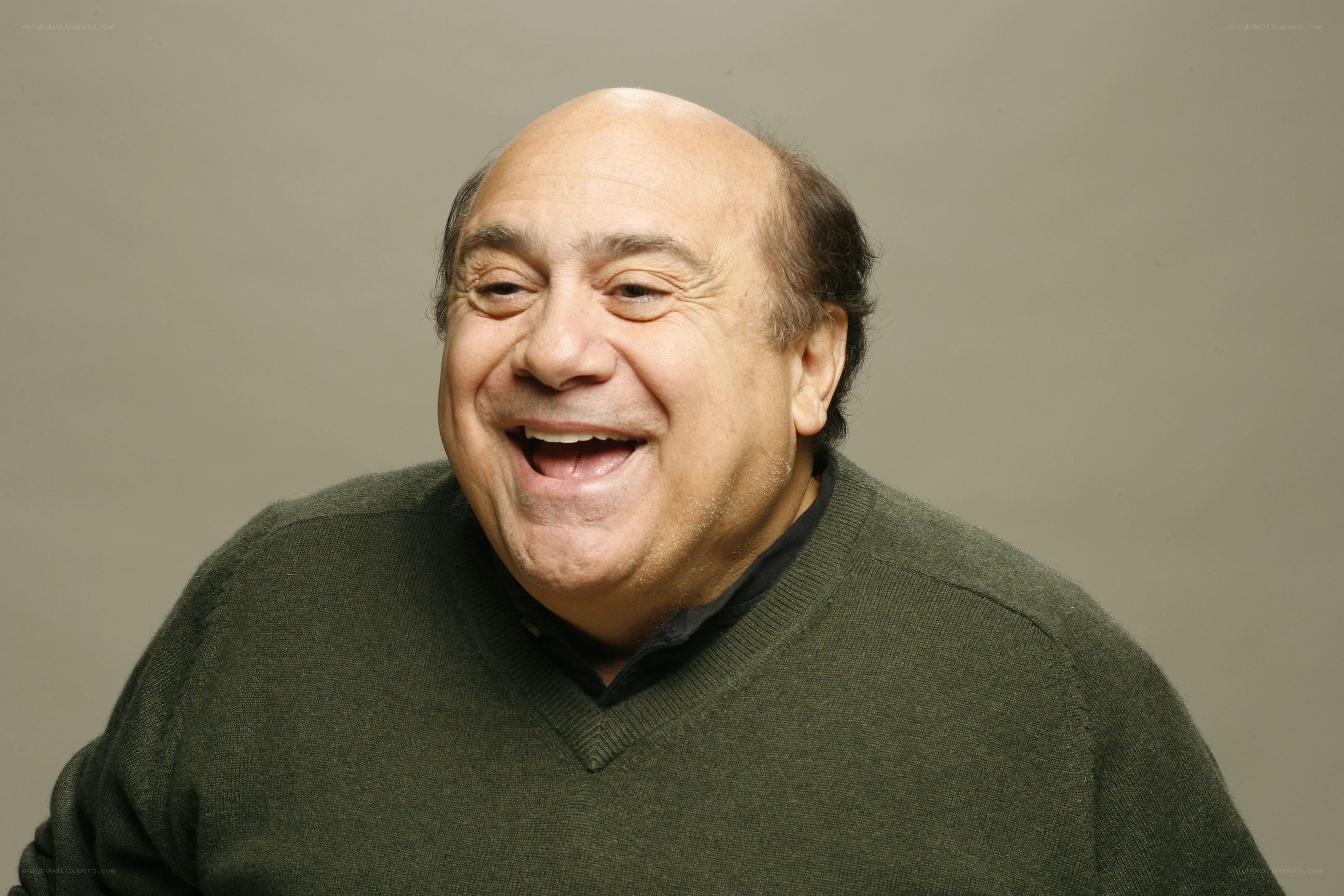 man laughing in green sweater