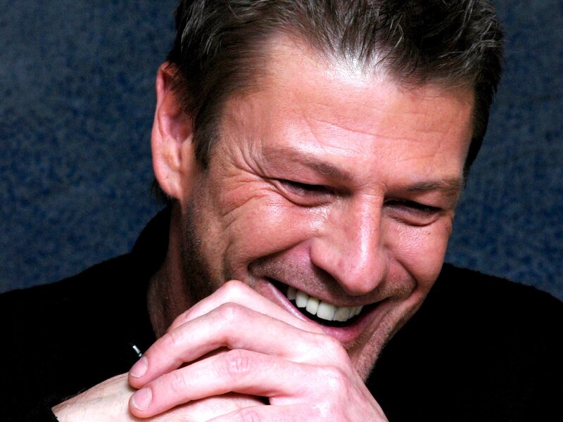 man laughing with hands clasped