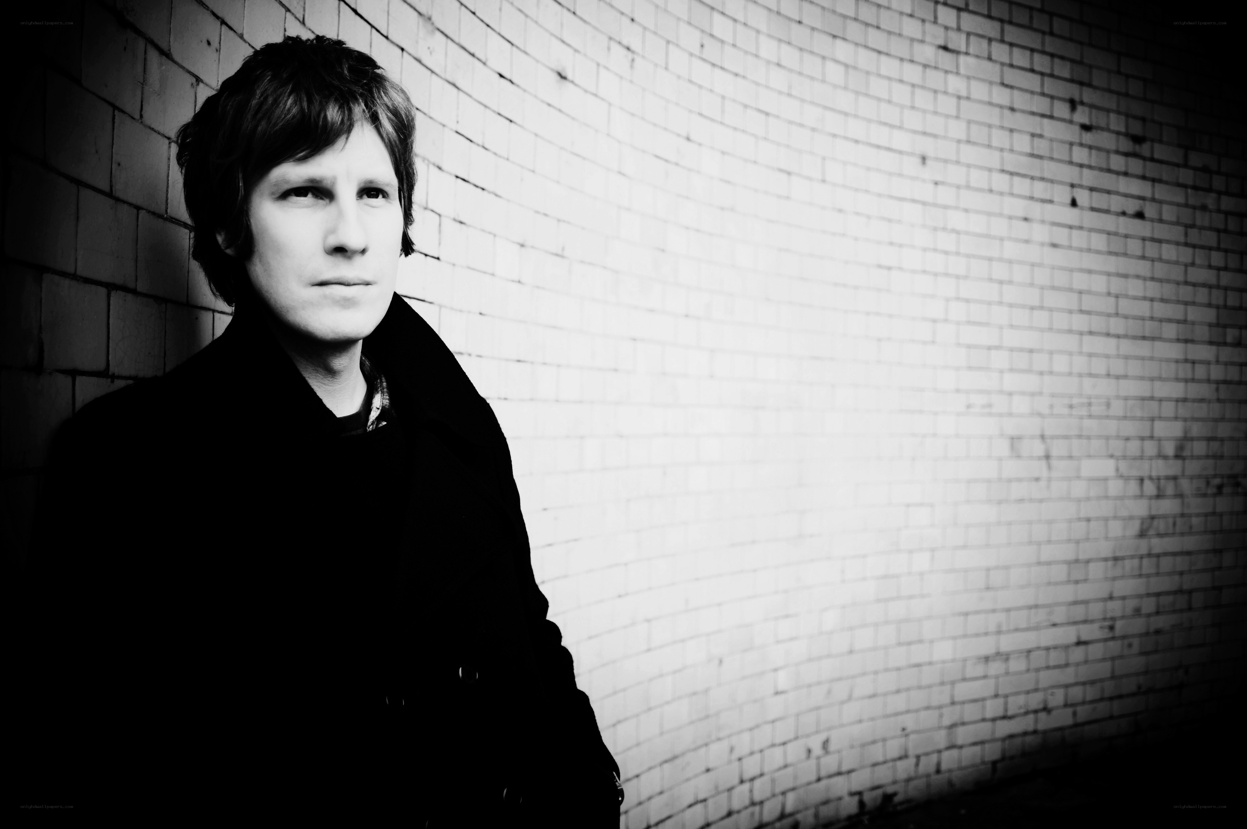 man leaning against brick wall