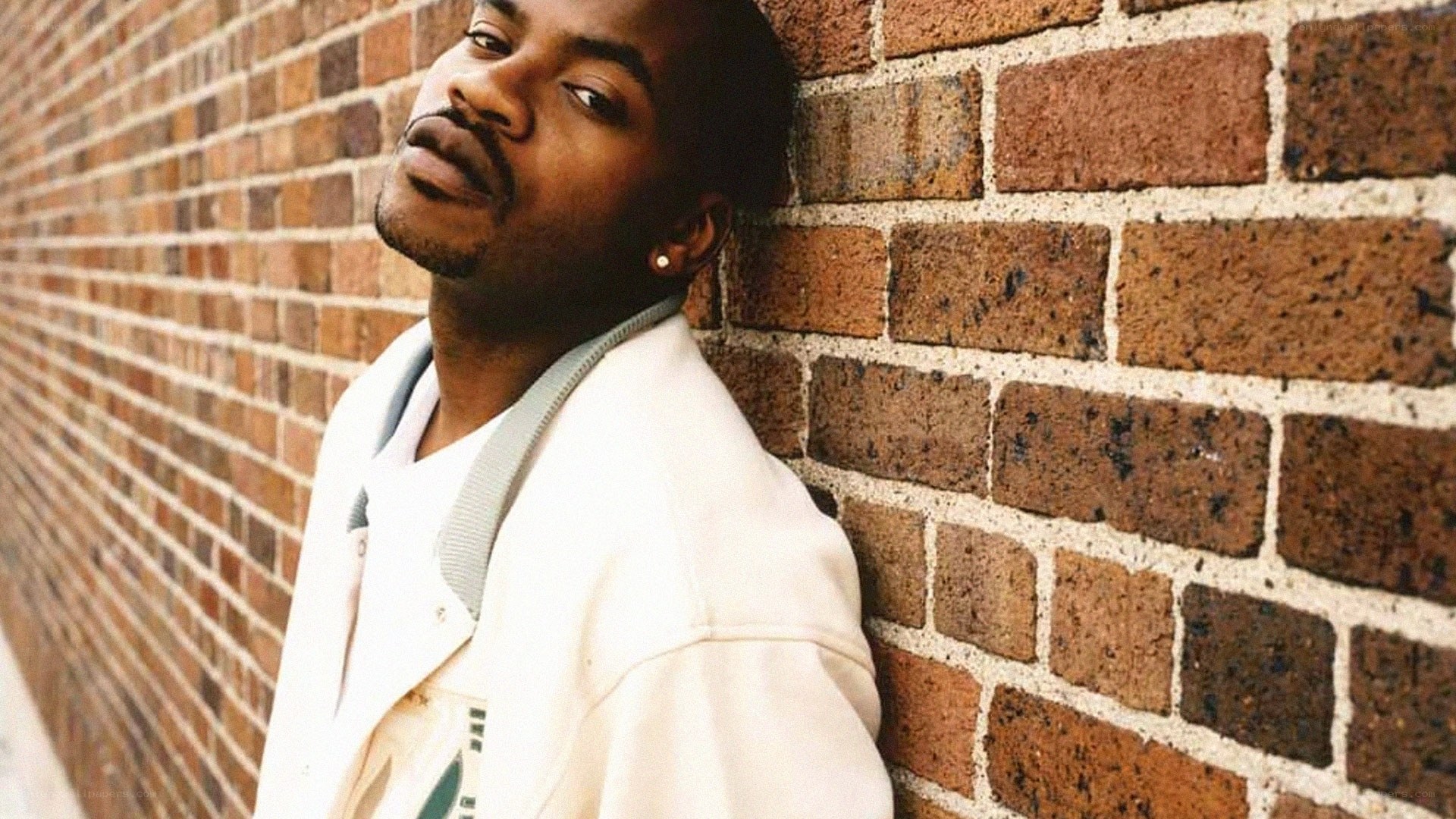 man leaning against brick wall