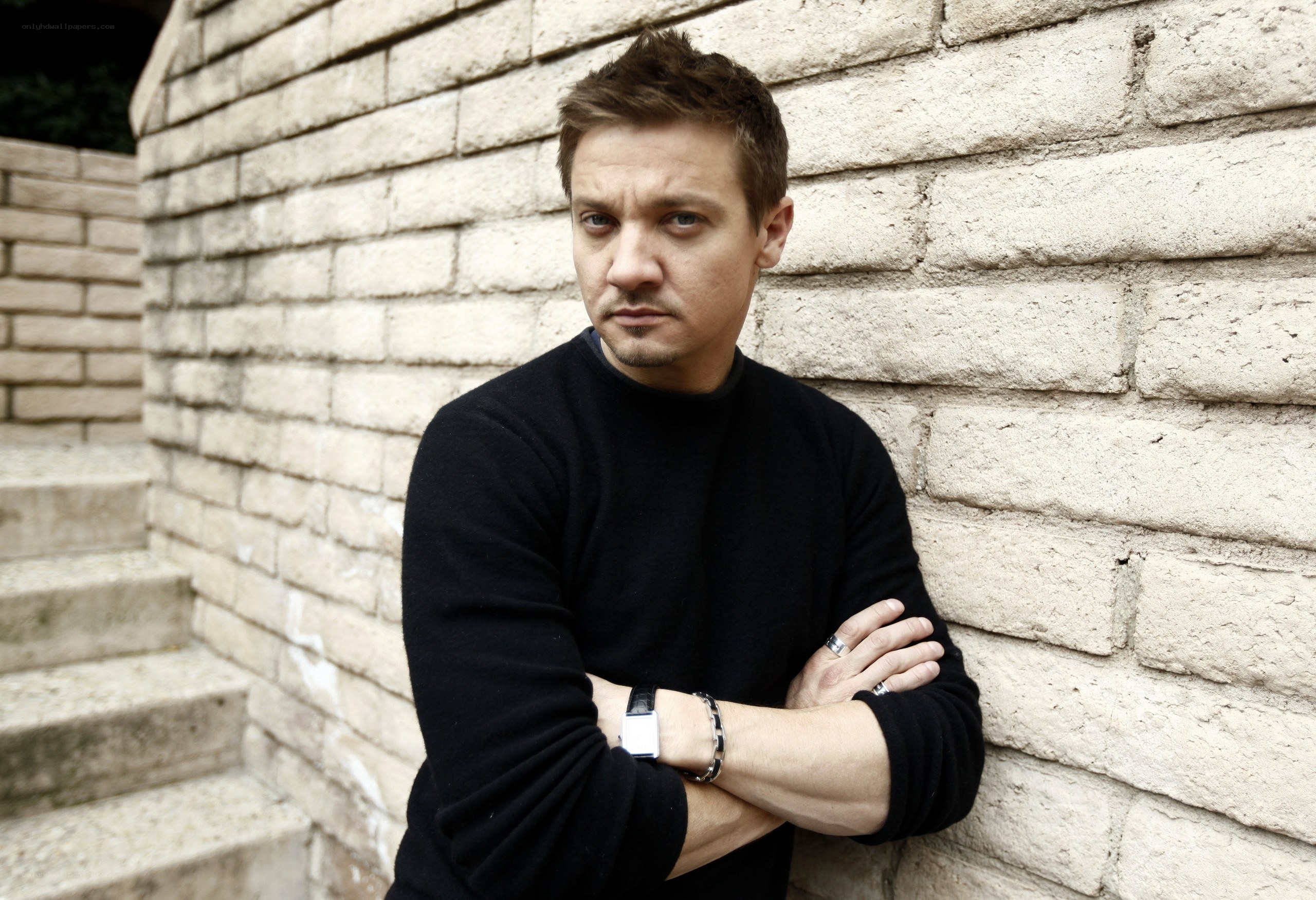 man leaning against brick wall