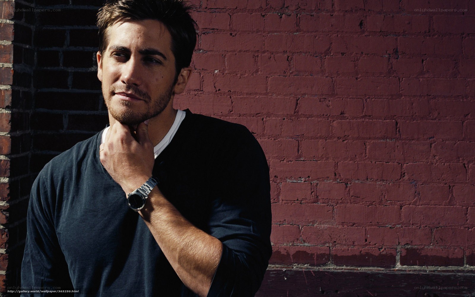 man leaning against brick wall