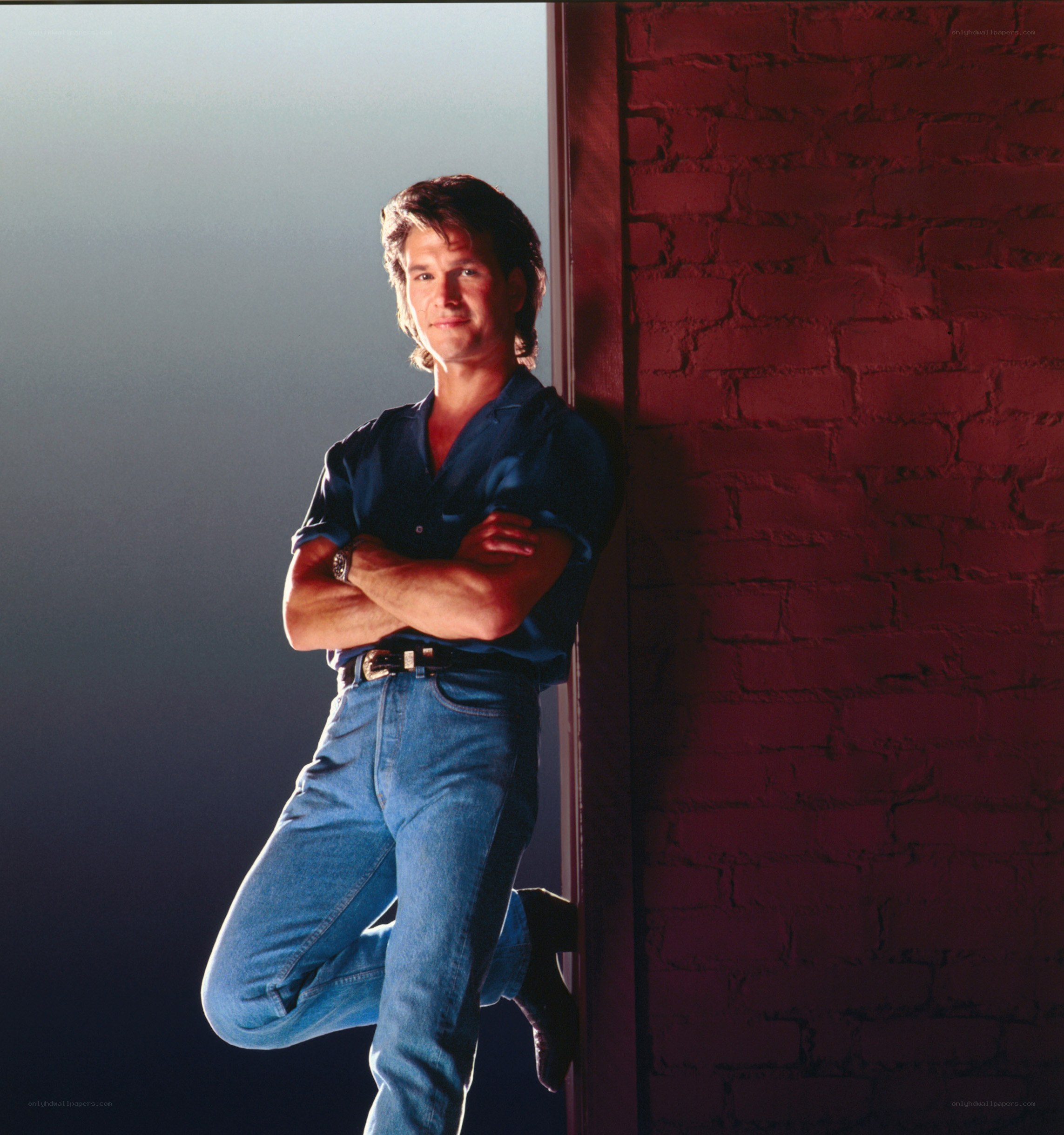 man leaning against brick wall
