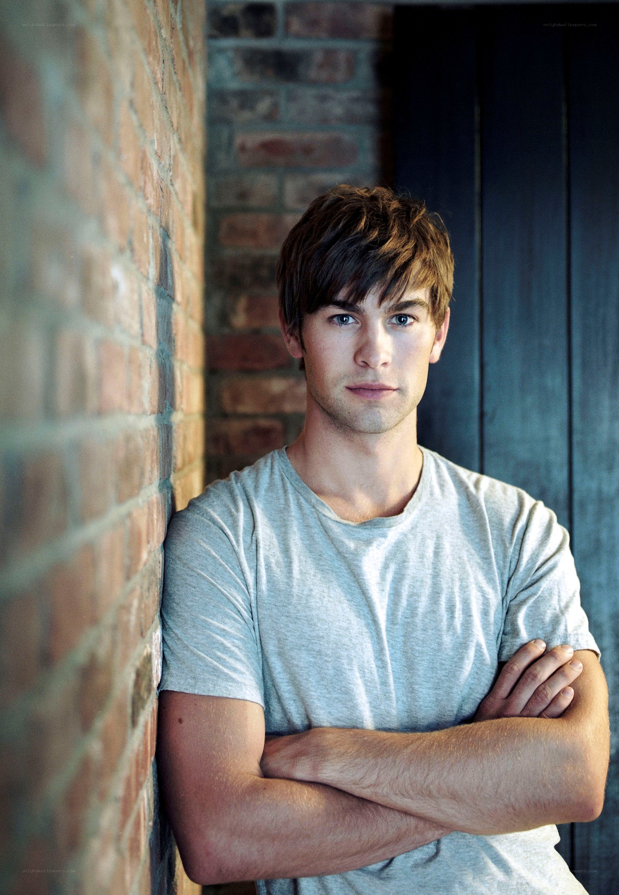 man leaning against brick wall