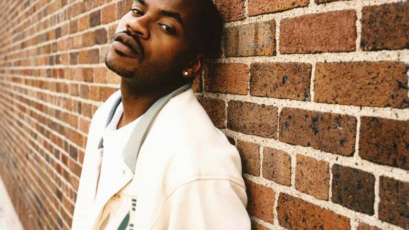 Man Leaning Against Brick Wall — Brown