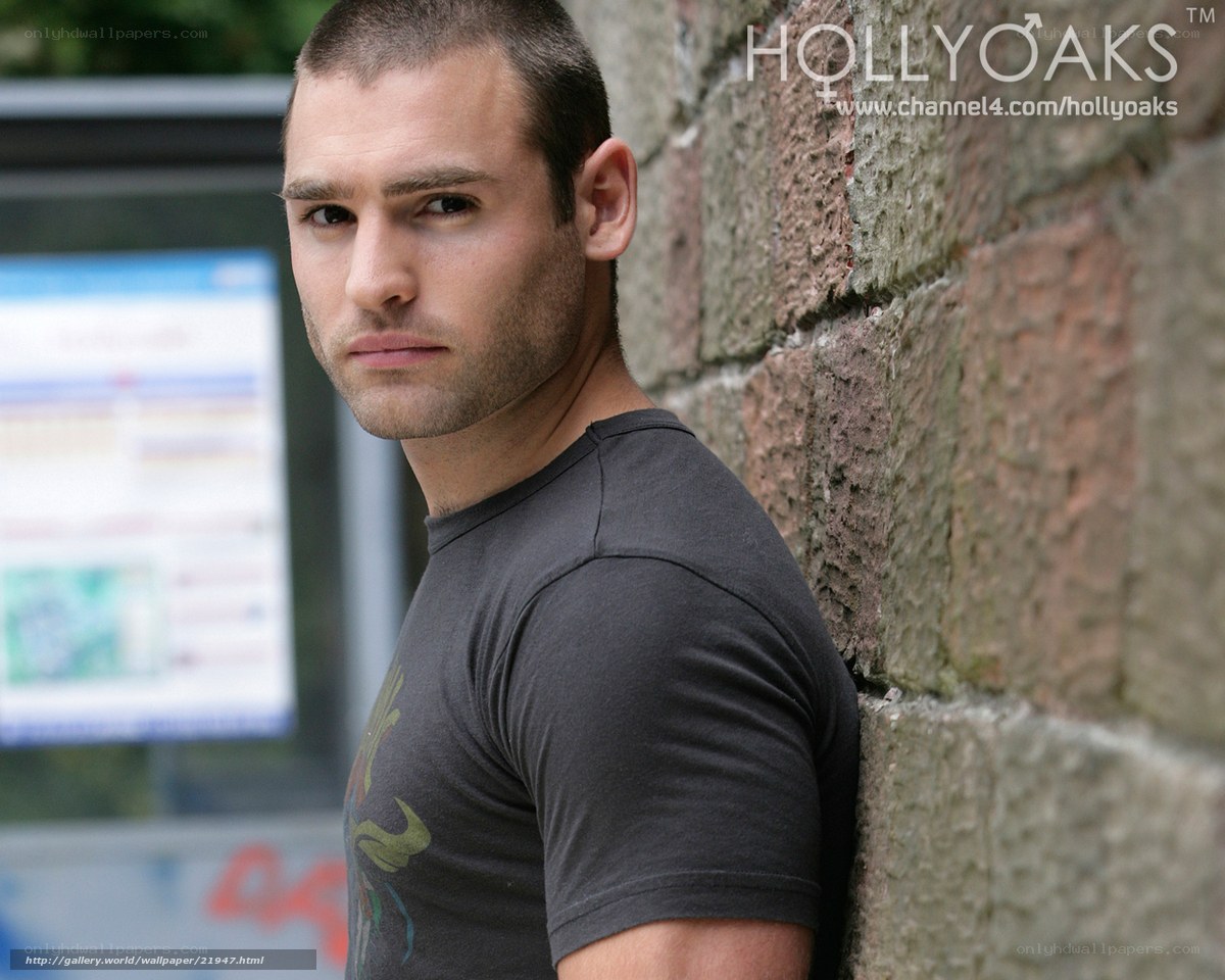 man leaning against brick wall