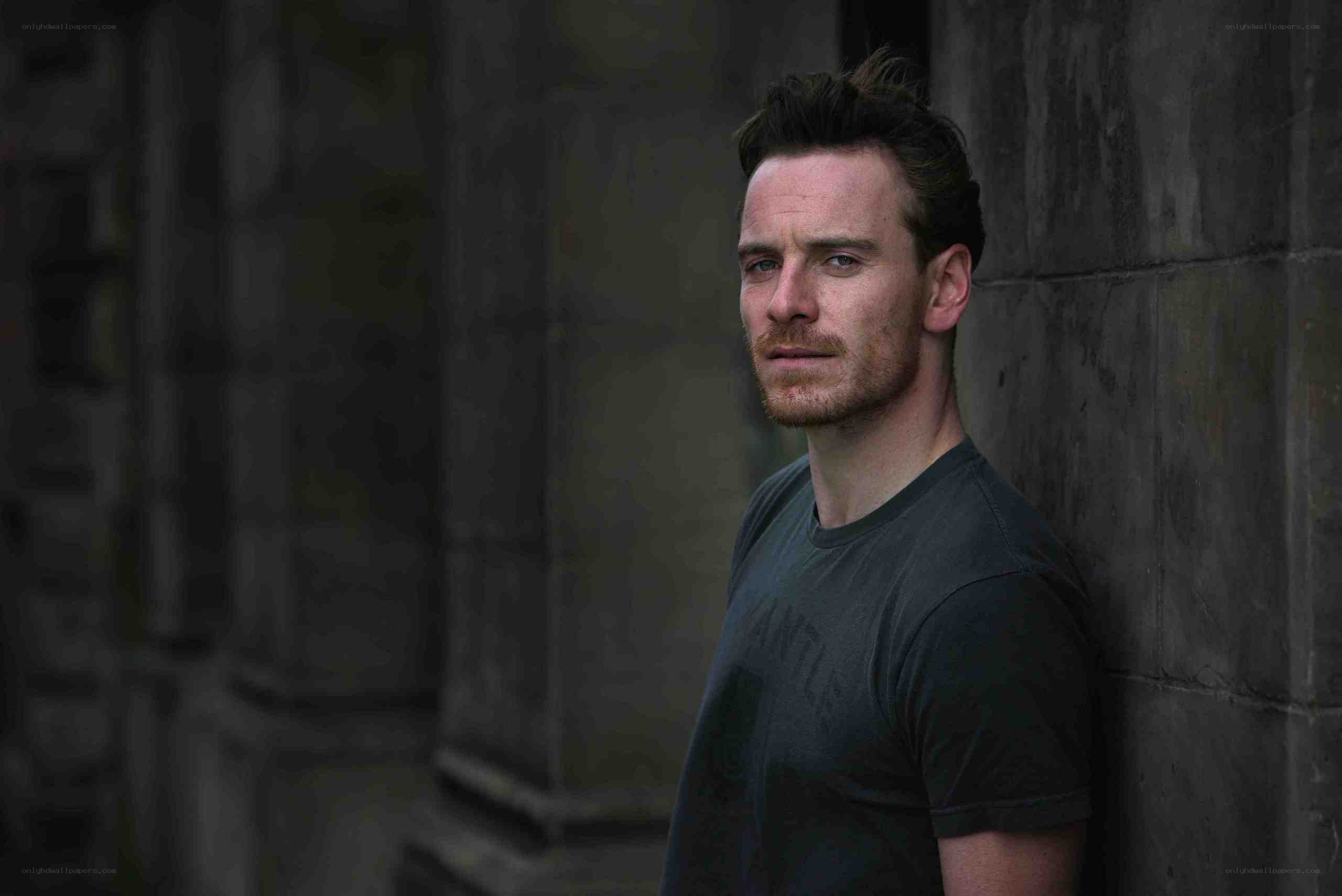 man leaning against stone wall