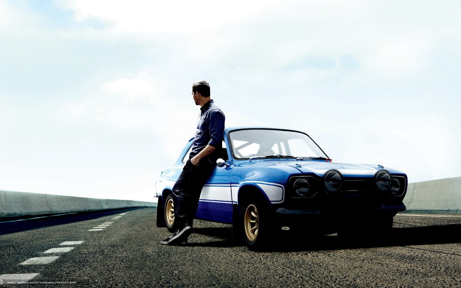 man leaning on blue car