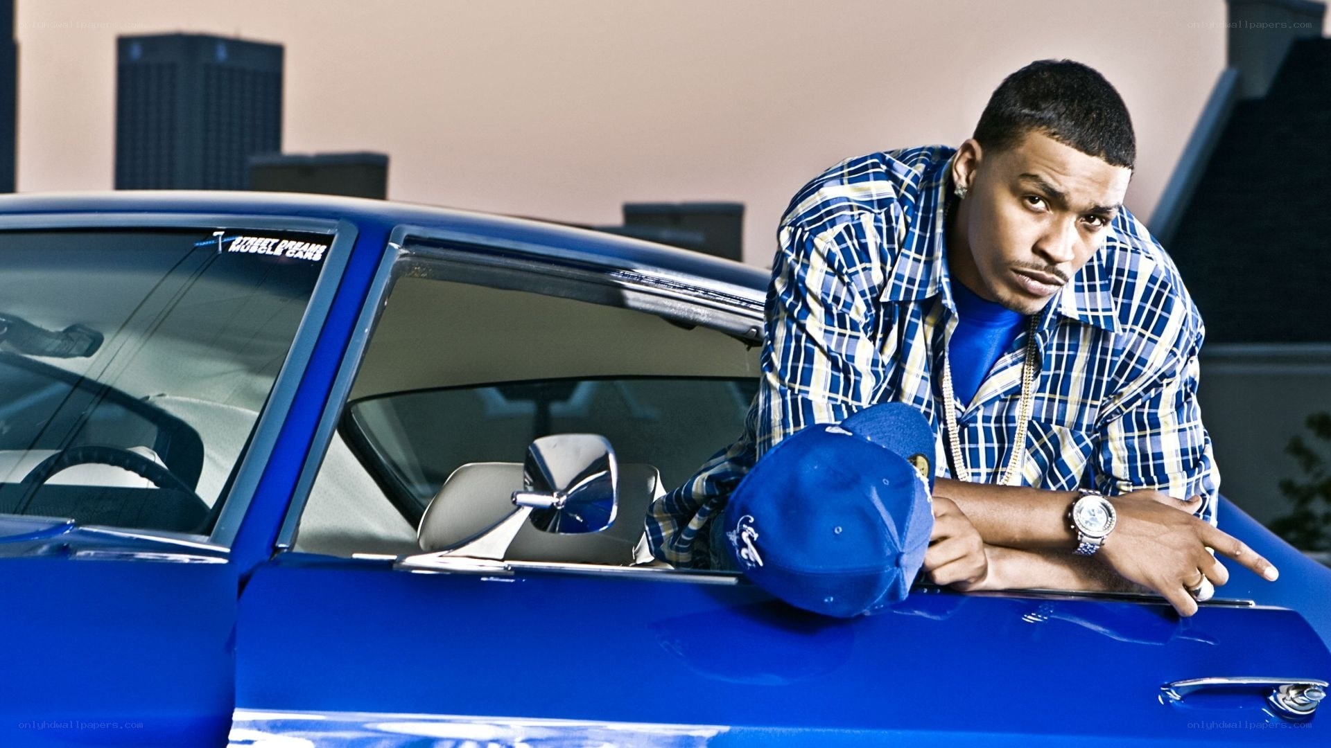 man leaning on blue car