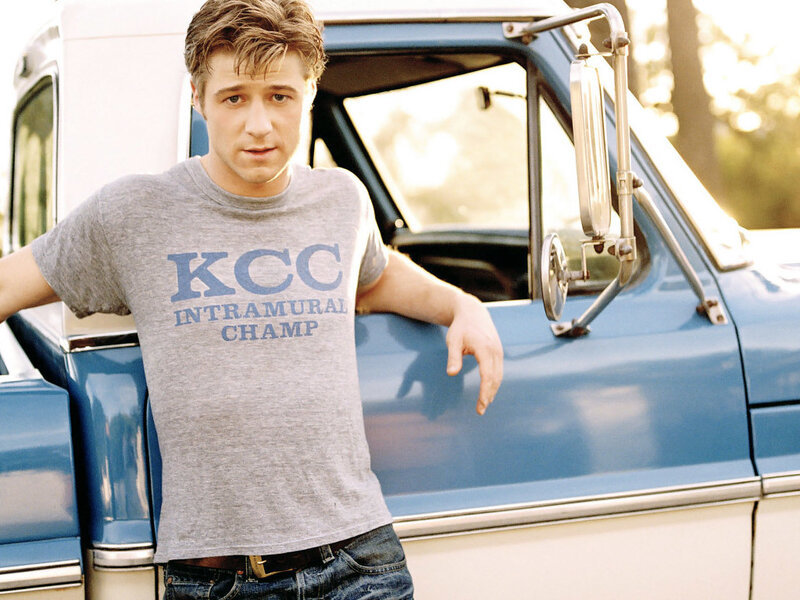 man leaning on blue truck