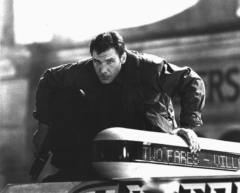 man leaning on car with gun