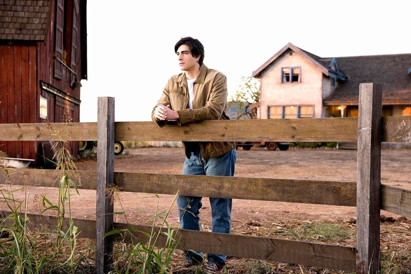 man leaning on fence at farm