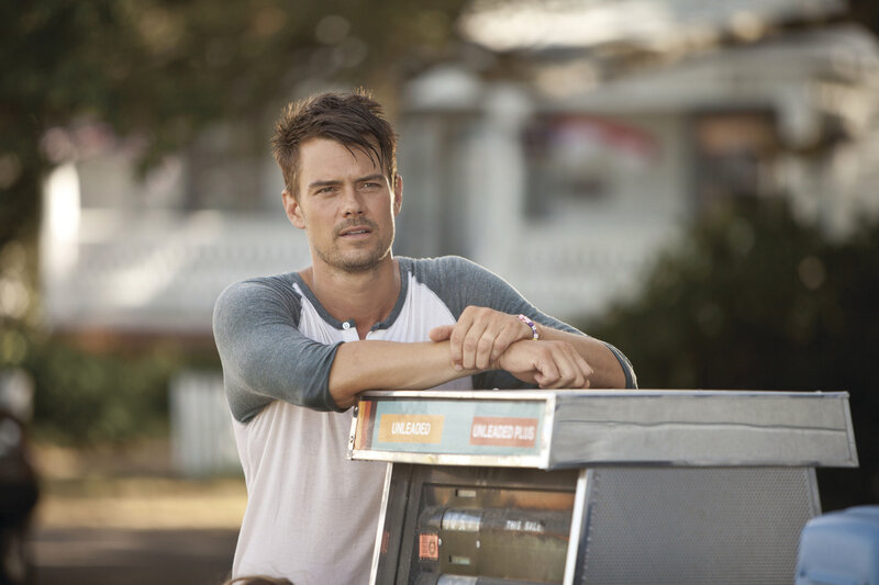 man leaning on gas pump