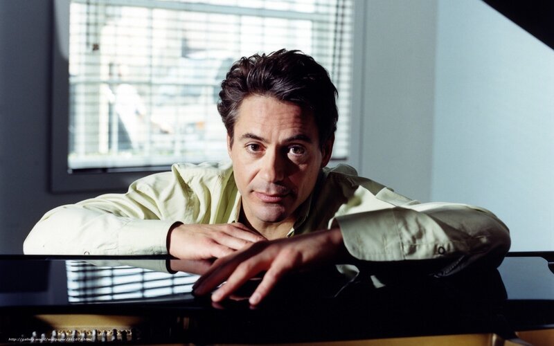 man leaning on piano